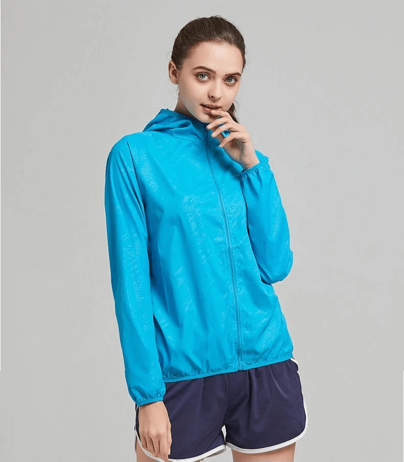 Woman wearing blue waterproof polyester hiking jacket SF2005, showcasing its sun-protective, breathable design perfect for outdoor activities.