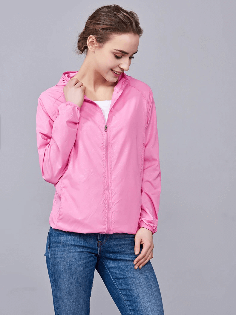 Woman wearing pink waterproof polyester hiking jacket, sun-protective and anti-UV, perfect for outdoor camping adventures.