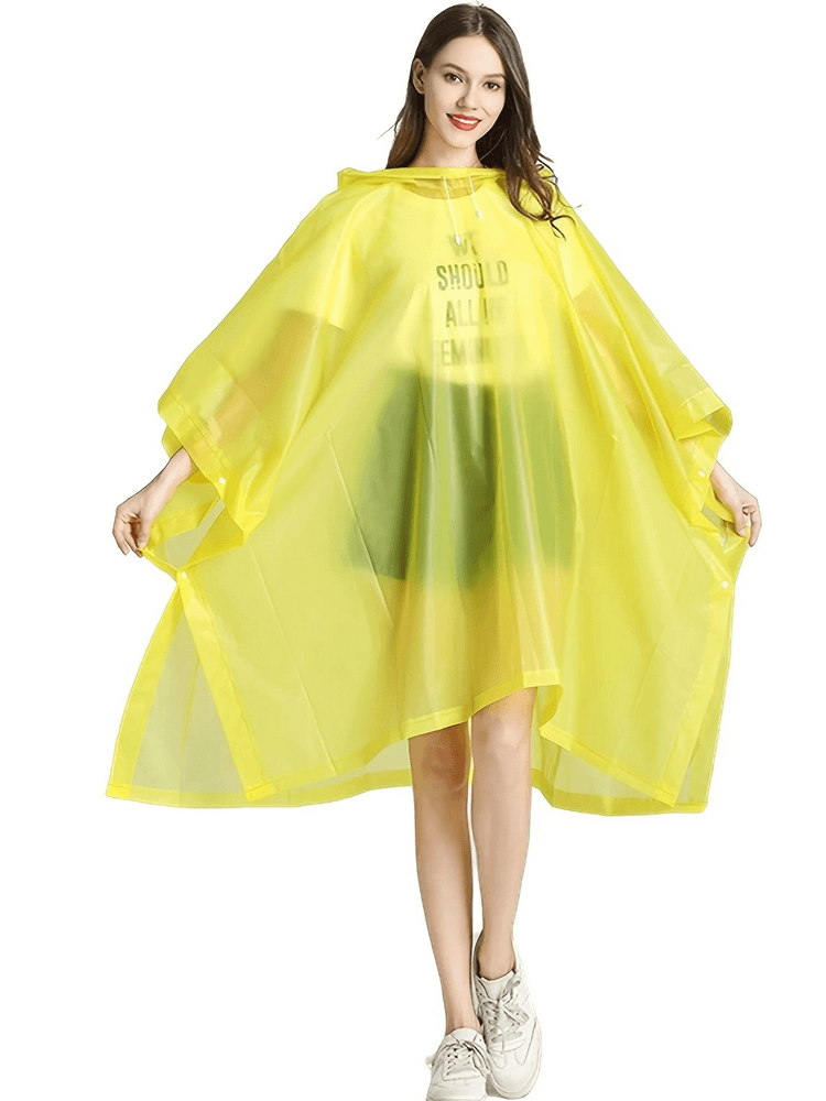 Woman wearing a yellow waterproof reusable transparent raincoat poncho, showcasing stylish weather protection.