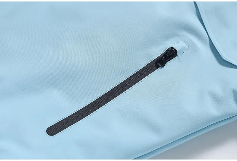 Close-up of Waterproof Ski Jacket with Hood's zipper pocket in light blue, showcasing durability and style for men and women.
