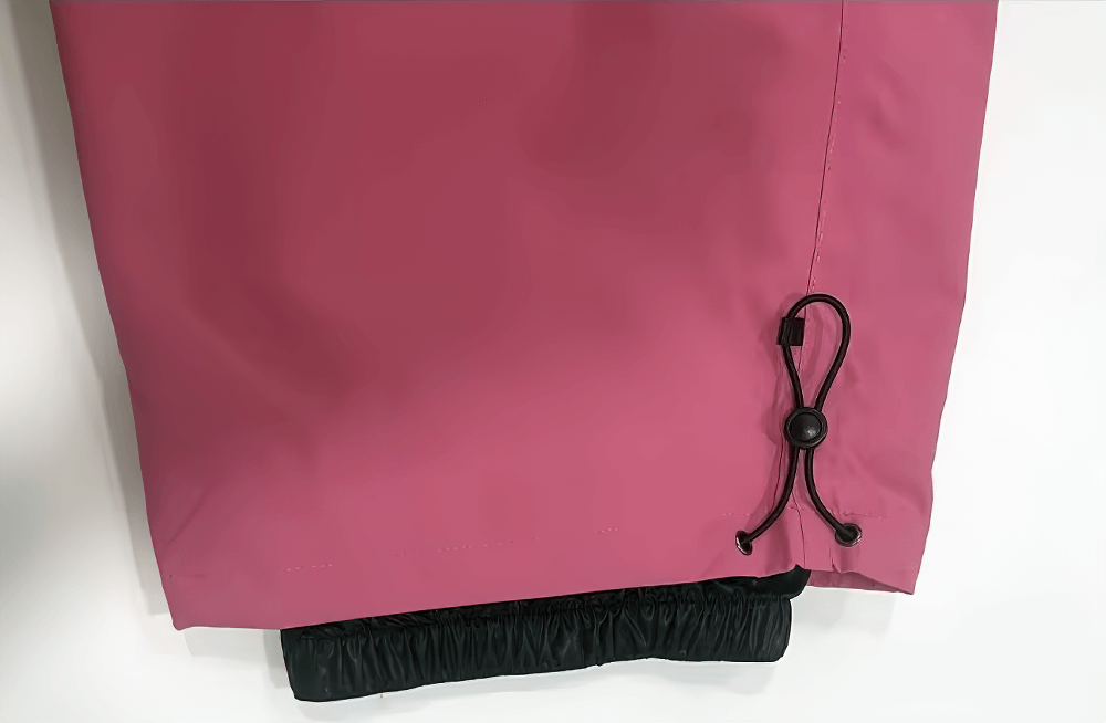 Close-up of a pink waterproof snowboarding jacket hem with adjustable drawstring for optimal fit and protection on the slopes.