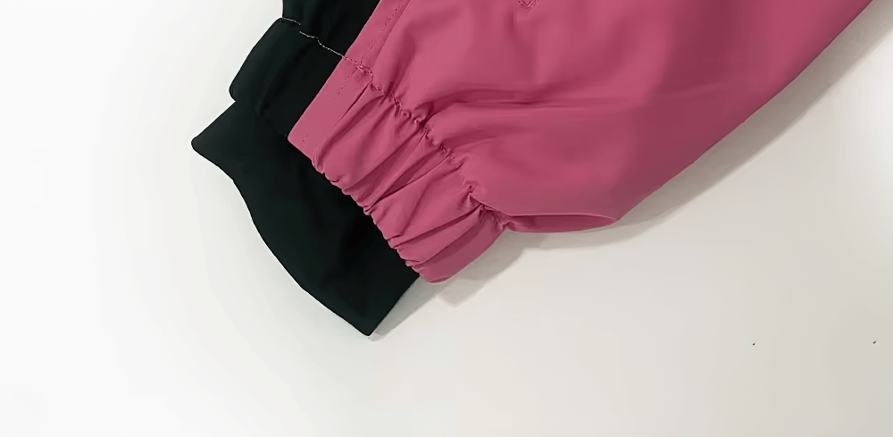 Close-up of pink waterproof snowboarding pants showcasing thermal windproof fabric and elastic cuffs.