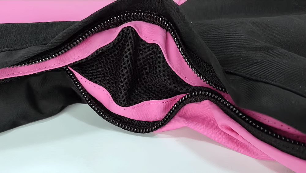 Close-up of waterproof snowboarding jacket's pink zipper and mesh lining, highlighting winter durability and style.