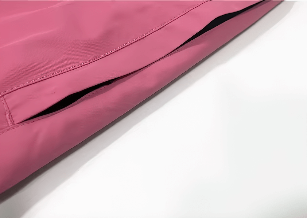 Close-up of pink waterproof snowboarding jacket with zipper, designed for winter sports and harsh weather conditions.