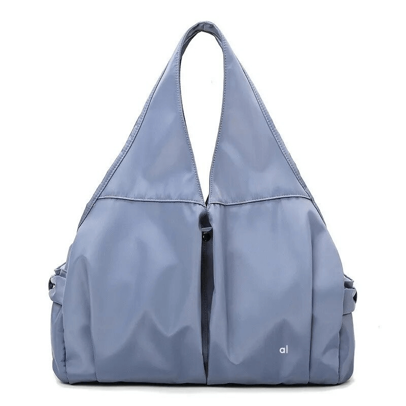 Waterproof roomy women's sports bag in blue with multiple pockets, perfect for active lifestyles and made from durable nylon material.
