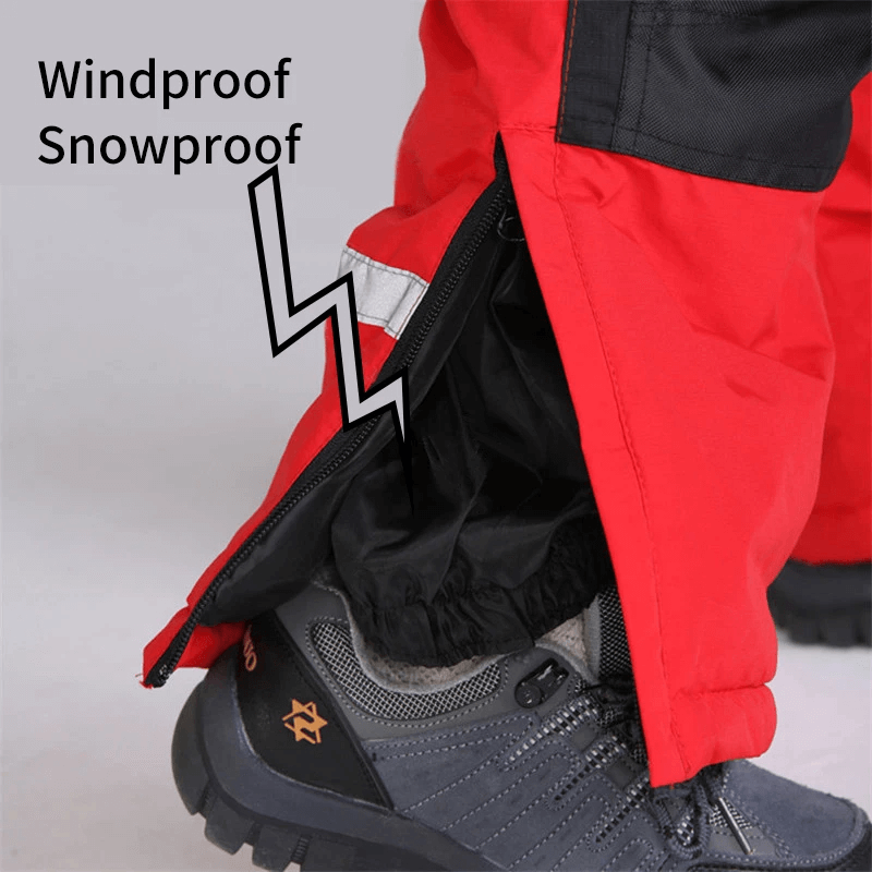Close-up of red waterproof ski jumpsuit leg with zip, showing its windproof and snowproof features, paired with sturdy snow boots.
