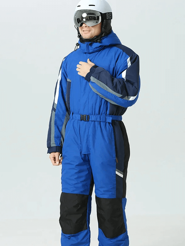 Man wearing blue waterproof ski jumpsuit with hood and fleece lining, designed for warmth and windproof protection, perfect for skiing.