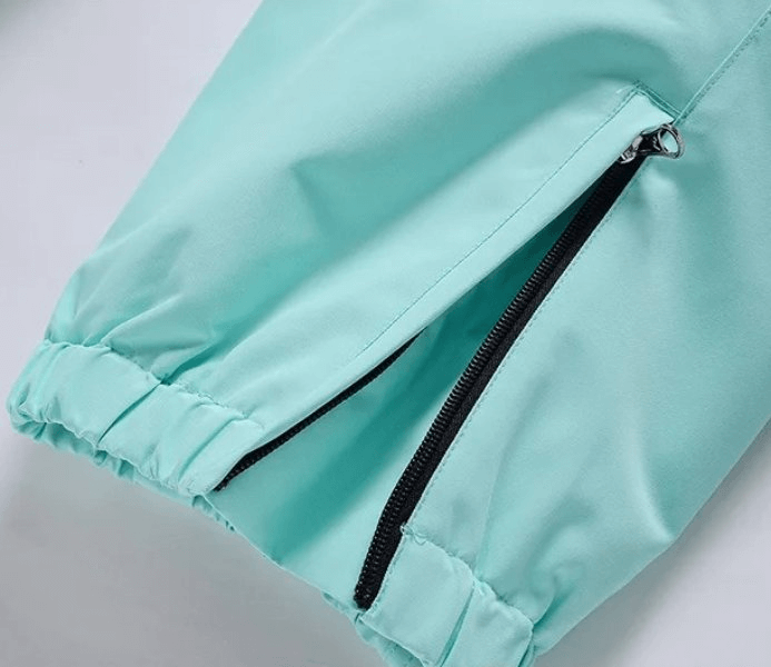 Close-up of waterproof windproof ski pants with pocket detail, showcasing high-quality polyester fabric in light blue. Unisex design.