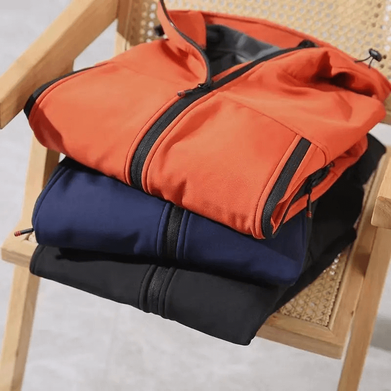 Stack of weather-resistant softshell hooded jackets in orange, blue, and black, perfect for outdoor activities like hiking and camping.