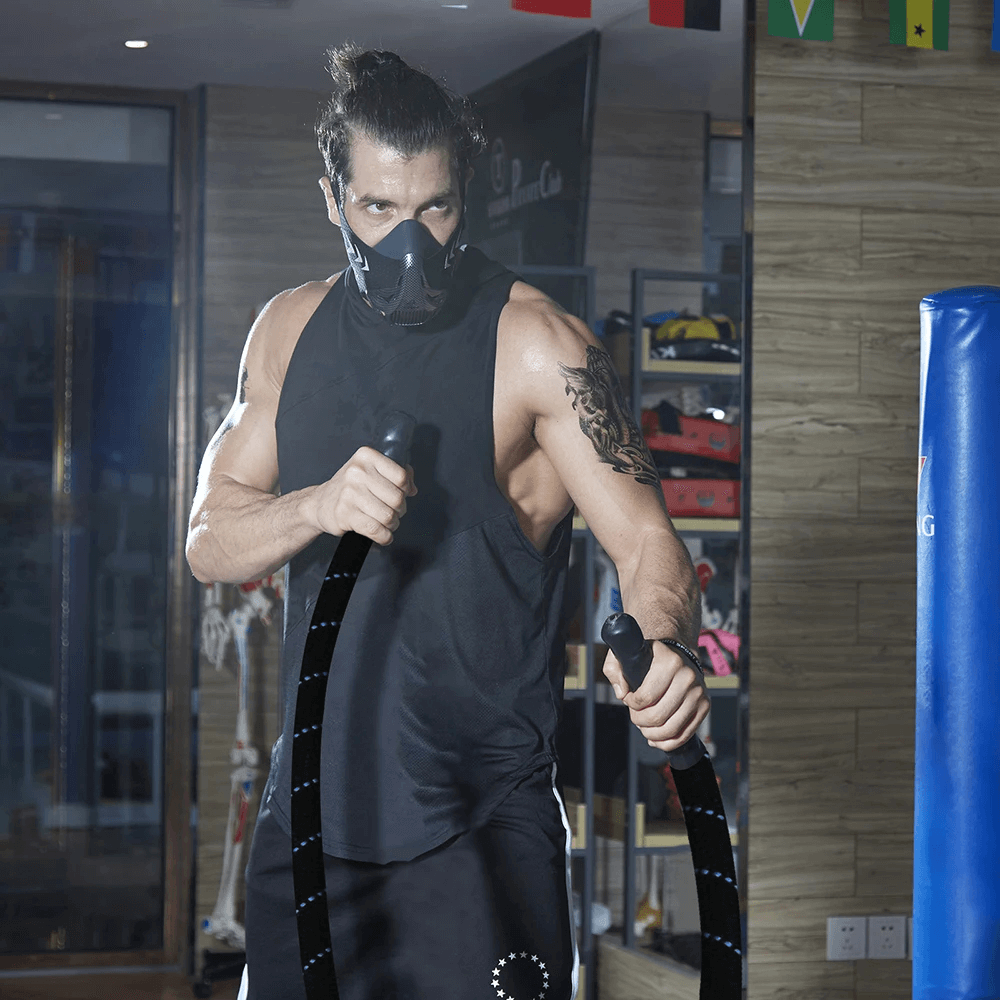 Man using Weighted Battle Jump Rope for Cardio Training - SF3494 indoors with workout mask, focusing on upper body strength and endurance.