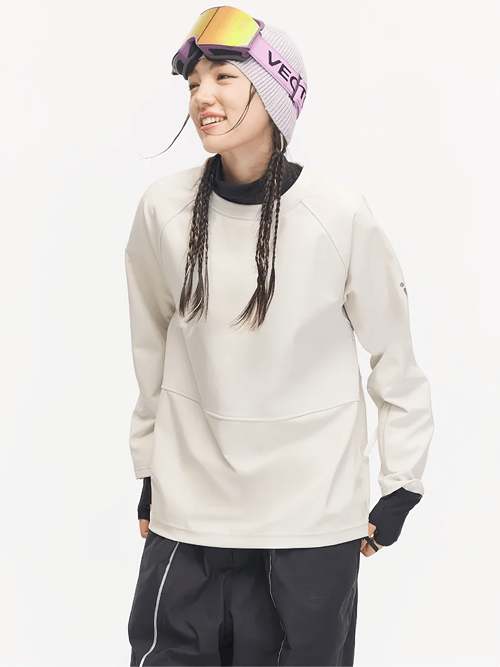 Winter snowboard pullover with thumb cuffs, armpit ventilation, windproof design, and snow card pocket, worn by a woman ready for slopes.