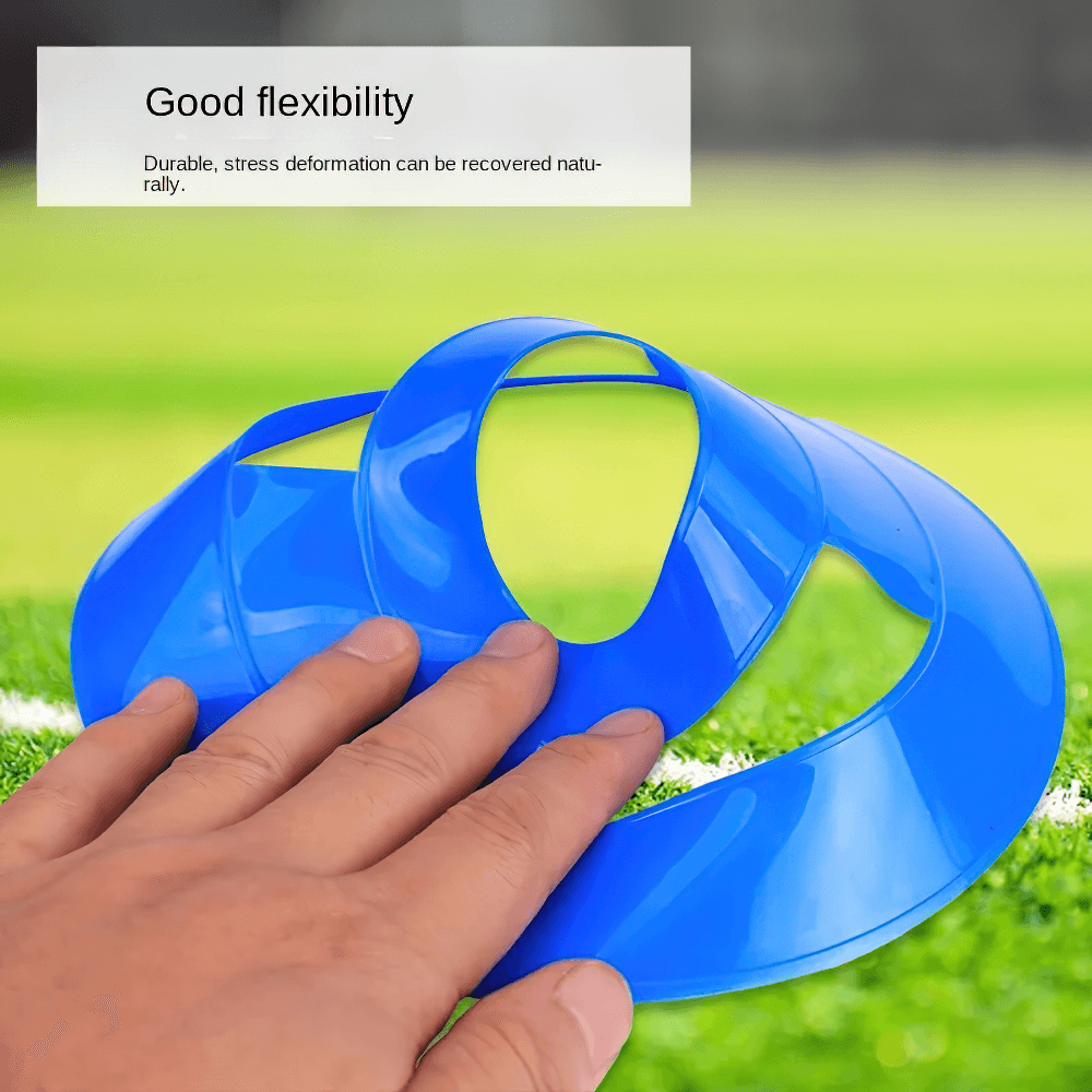 Close-up of flexible blue soccer training cones with hand demonstrating durability on a grassy field.