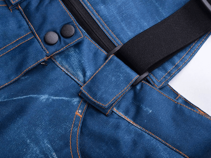 Close-up of windproof thermal snowboard denim pants with suspenders, showing zipper and button details.