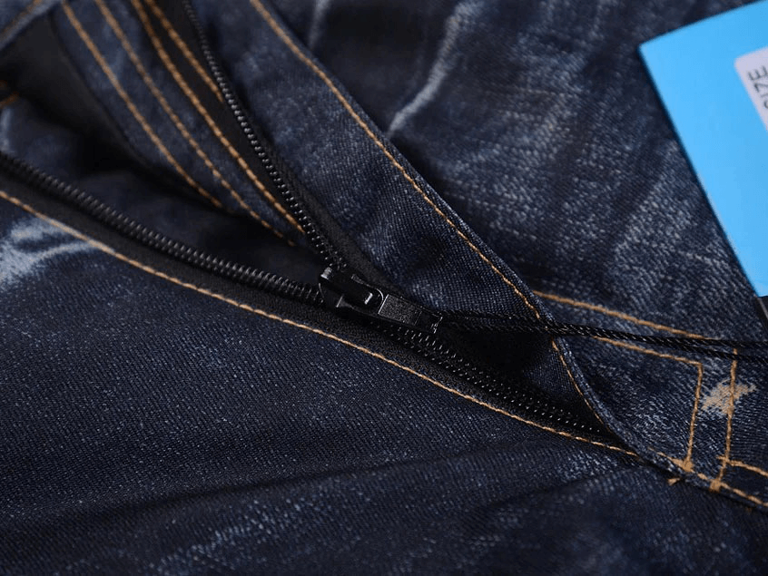 Close-up of zipper on windproof thermal snowboard denim pants for secure fit.