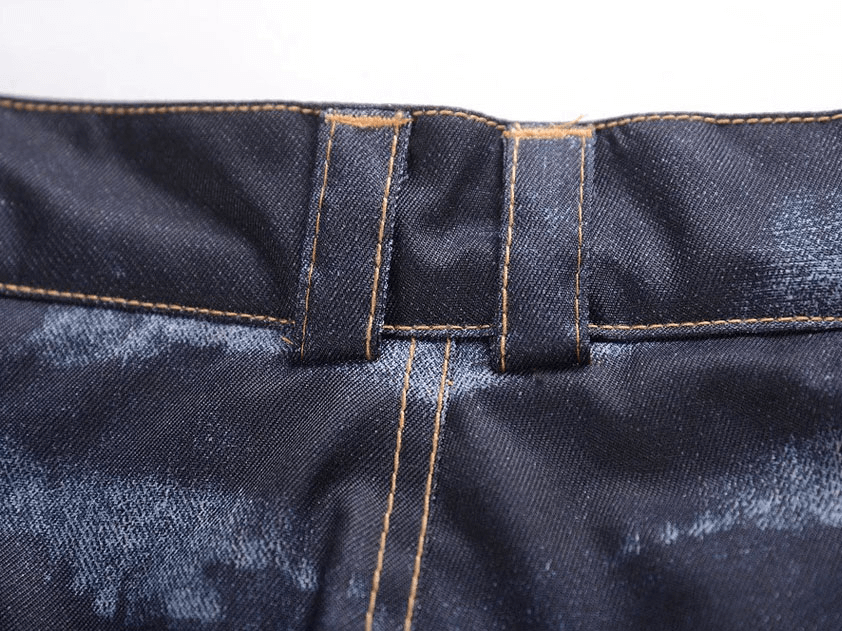 Close-up of denim waistband and stitching on windproof thermal snowboard pants with suspenders.