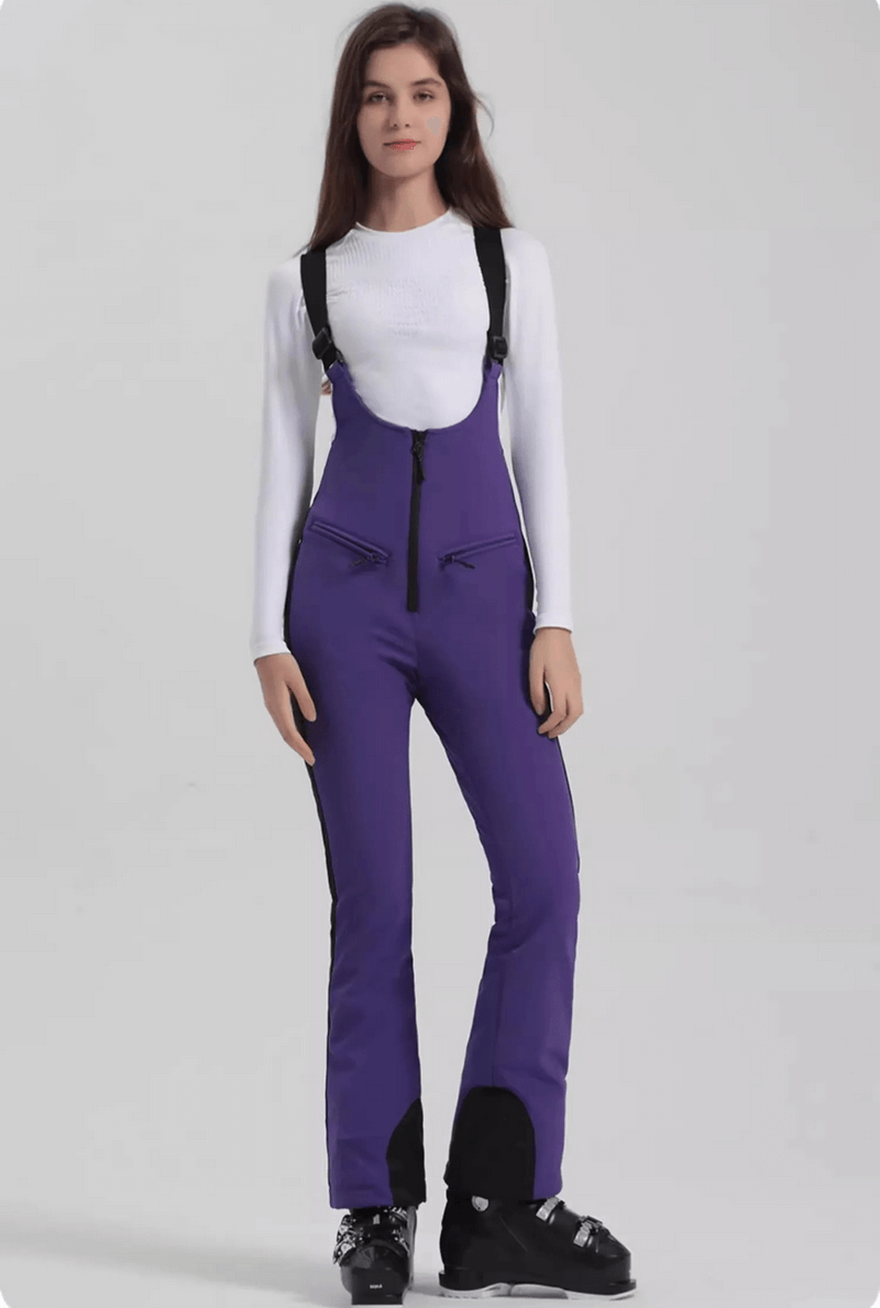 Woman wearing purple windproof waterproof thermal pants for skiing, featuring zipper closure and suspenders.