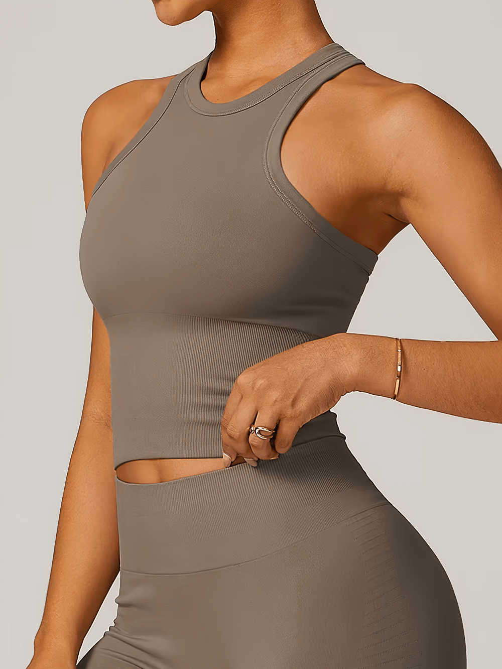 Woman wearing a sleek, breathable, quick-dry fitness tank top in gray, perfect for workouts and sporty casual looks.