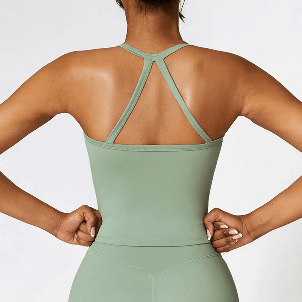 Back view of woman wearing green cross-back breathable push-up tank top for fitness