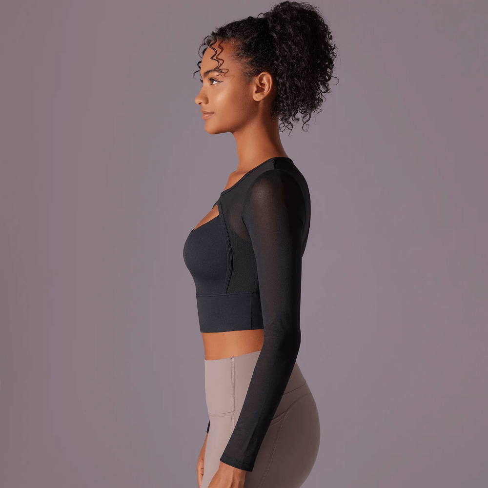 Woman modeling a black quick-dry mesh yoga crop top with long sleeves and chest pads, designed for active women.
