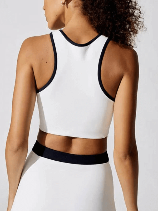 Woman wearing a white breathable crop tennis tank top made of polyester and spandex, perfect for staying cool on the court.