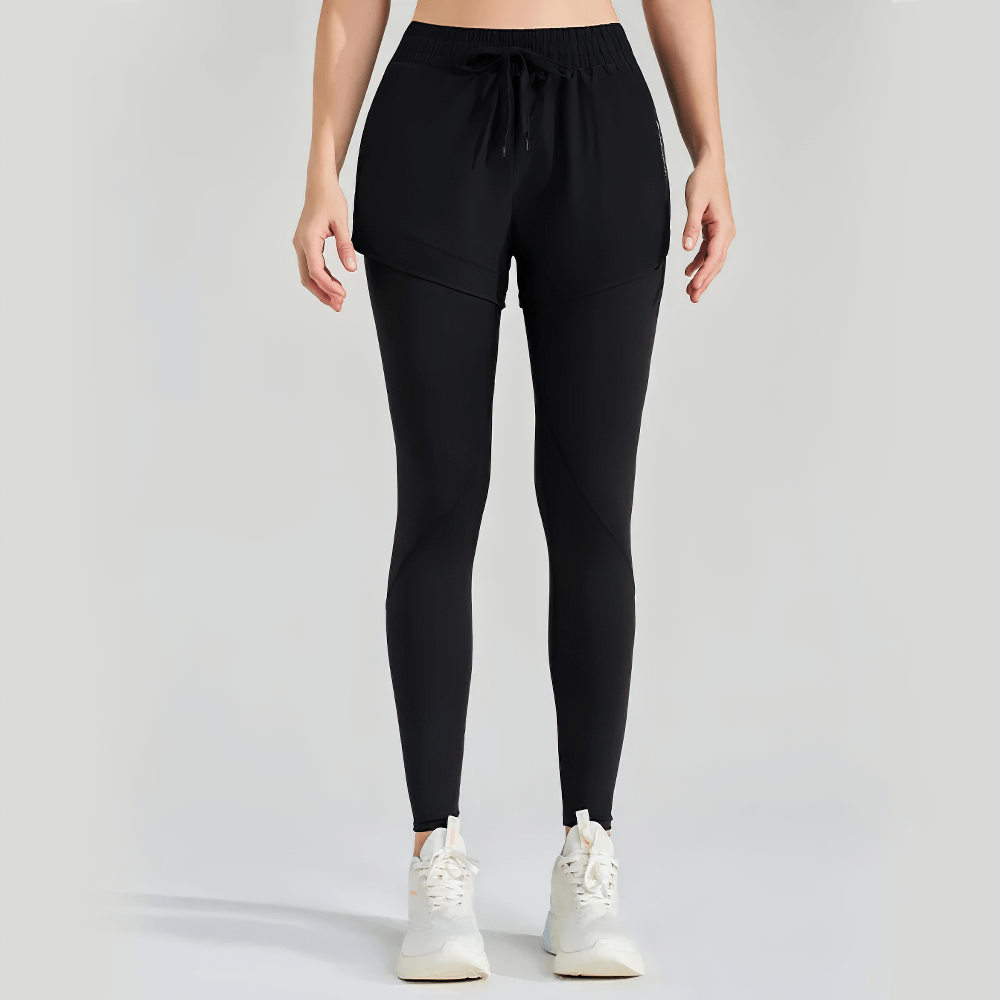 Woman wearing black ankle-length fake two-piece yoga pants with utility pockets and stretchy fit, perfect for workouts and casual fitness.