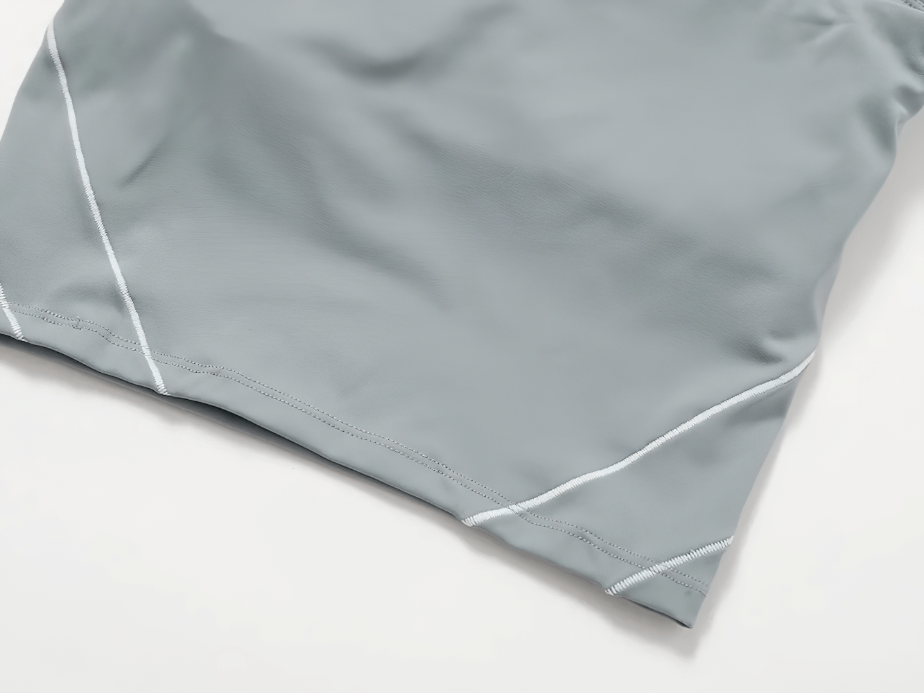 Light grey athletic fabric with white stitch accents, showcasing breathable and quick-dry material for women's sportswear.