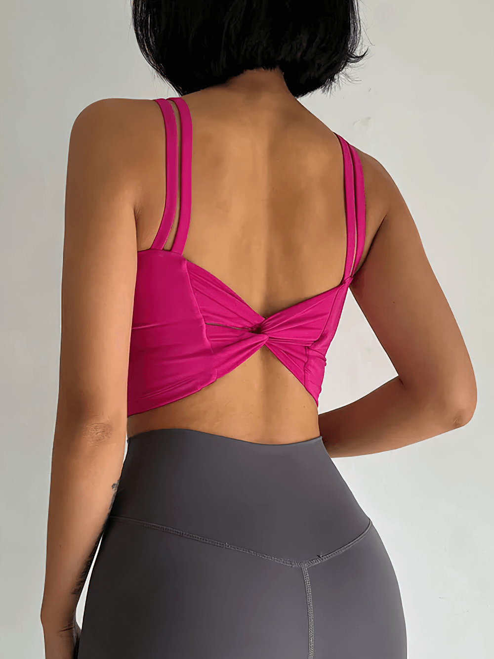 Back view of Women's Back-Knot Yoga Sports Bra with Fixed Pads - SF4061 in vibrant pink showing stylish knotted back design.