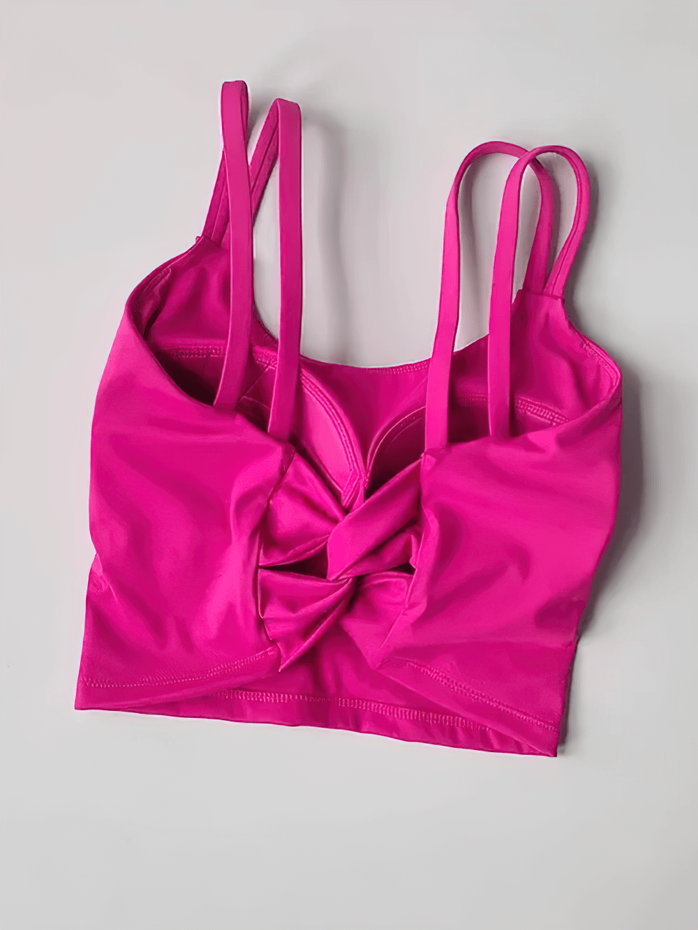 Vibrant pink Women's Back-Knot Yoga Sports Bra with Fixed Pads - SF4061, featuring knotted back design and sleek straps for gym workouts.