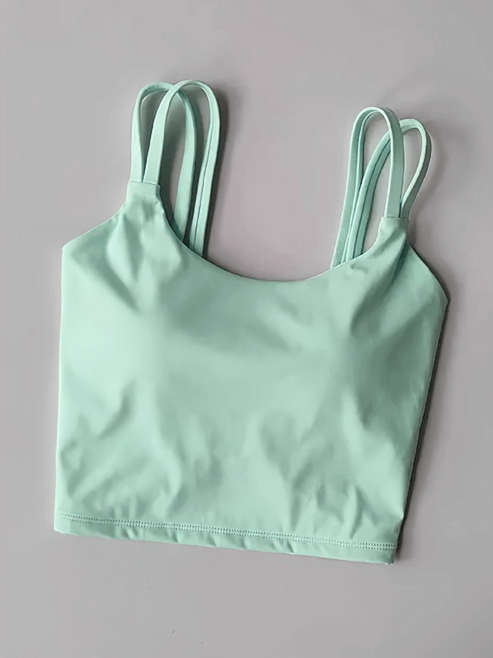 Women's Back-Knot Yoga Sports Bra with Fixed Pads - SF4061 in mint green, featuring sleek design and double straps on pastel backdrop.
