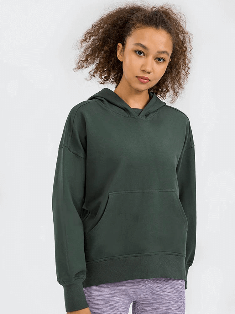 Woman wearing a green batwing sleeves hoodie for running, featuring a cozy hood and front pocket, perfect for outdoor activities.