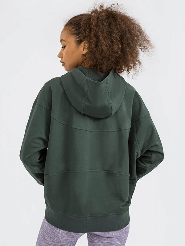Back view of a woman wearing a green batwing sleeve hoodie for running, showcasing its loose fit and hooded design.