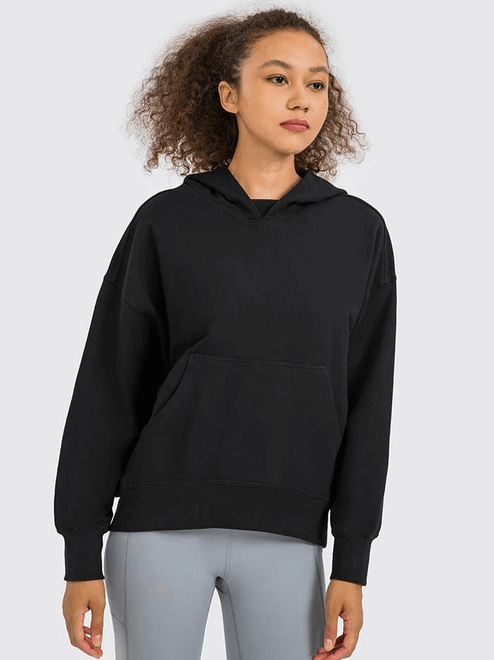 Woman wearing a black batwing sleeve hoodie, perfect for running and outdoor activities, with a pocket and hooded design.