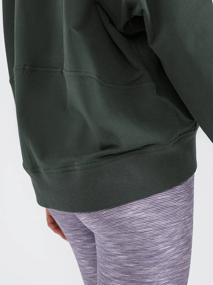 A close-up of a women's dark green batwing sleeve hoodie with additional pocket details, perfect for stylish and warm outdoor activities.