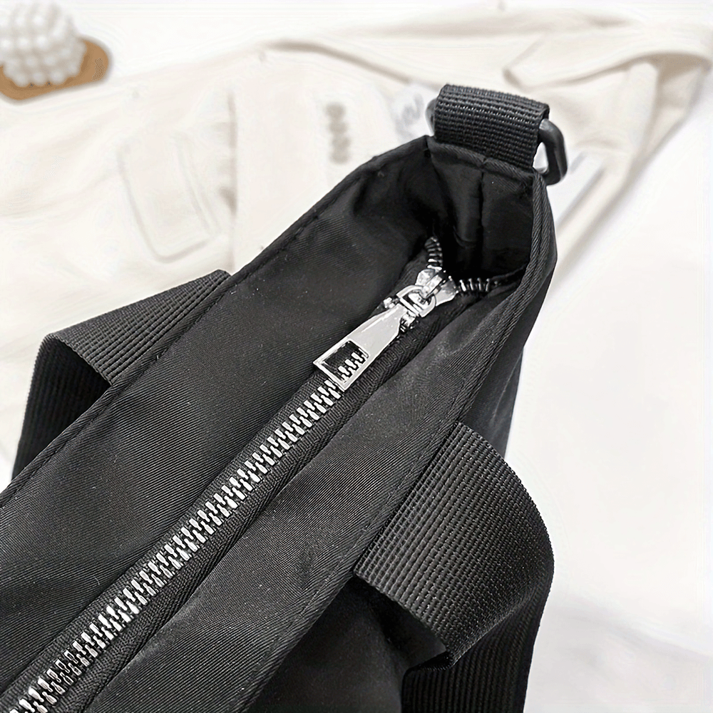 Close-up of durable black women's tote bag with zipper and adjustable strap, perfect for travel and everyday use.