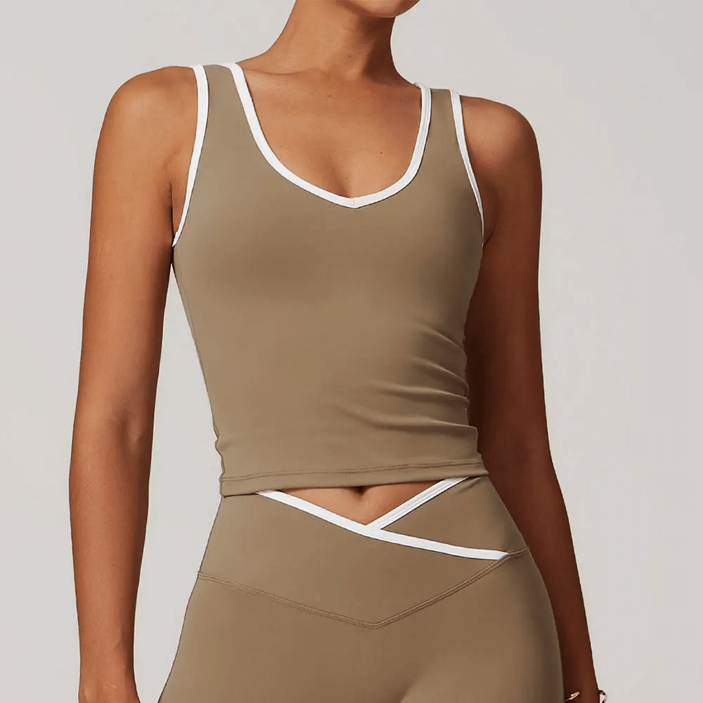 Woman wearing a sleek breathable tank top with contrast trim, styled for sporty casual wear.
