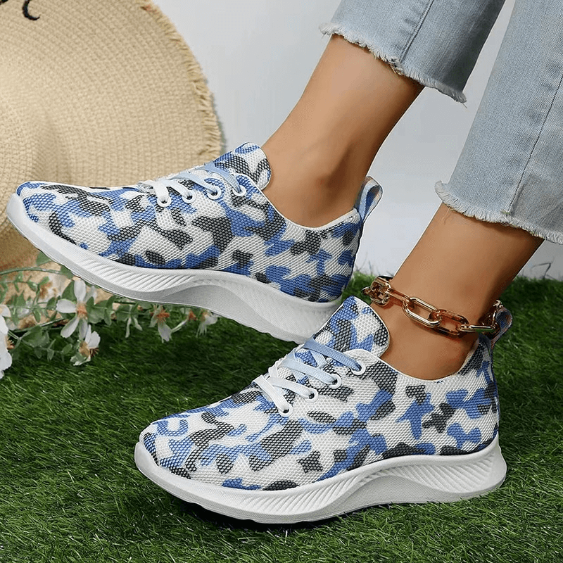 Women's breathable mesh non-slip sports shoes SF1406 in blue camouflage pattern with lace-up and rubber outsole on grass.