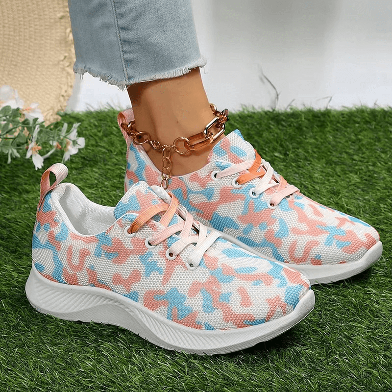 Women's camouflage pattern mesh sports shoes with lace-up, featuring non-slip rubber outsole, displayed on grass