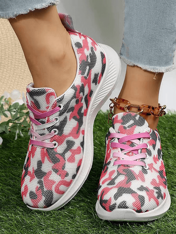 Women's Breathable Mesh Non-Slip Sports Shoes in pink camouflage, lace-up design on grass.