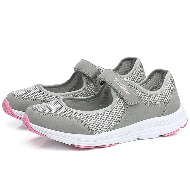 Women's breathable flat sneakers, gray with pink accents, lightweight mesh design, hook and loop closure, fashion-forward comfy shoes.