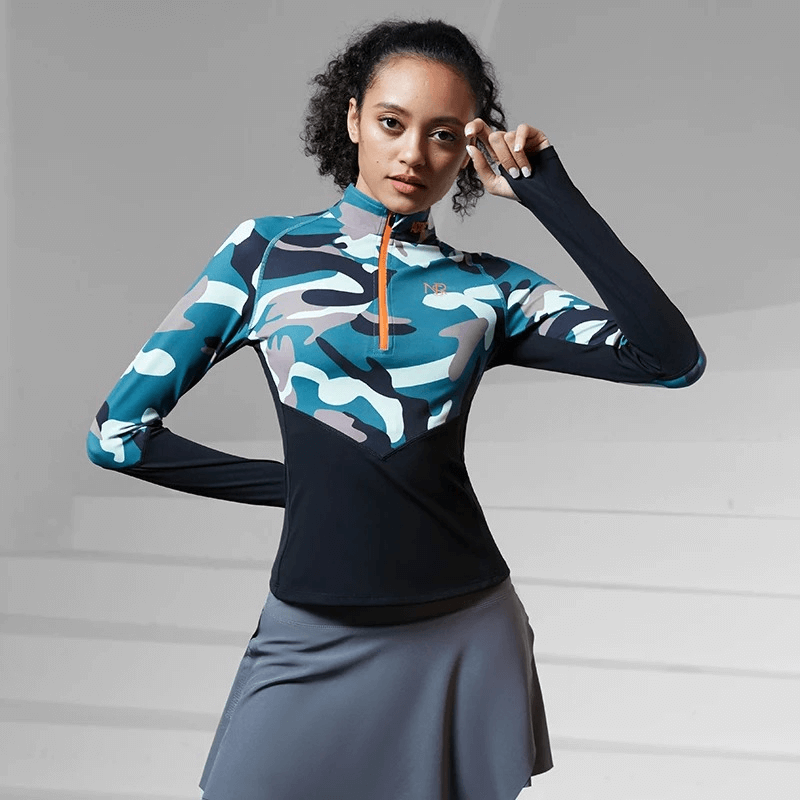 Woman wearing a women's camo print long sleeves sport shirt, designed for all seasons with breathable nylon-spandex blend for athletic performance.