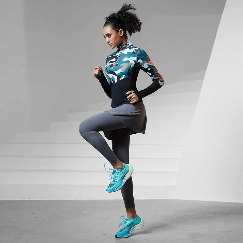 Woman in camo print long sleeve sport shirt demonstrating athletic pose for all-season use, showcasing breathable nylon spandex fabric.