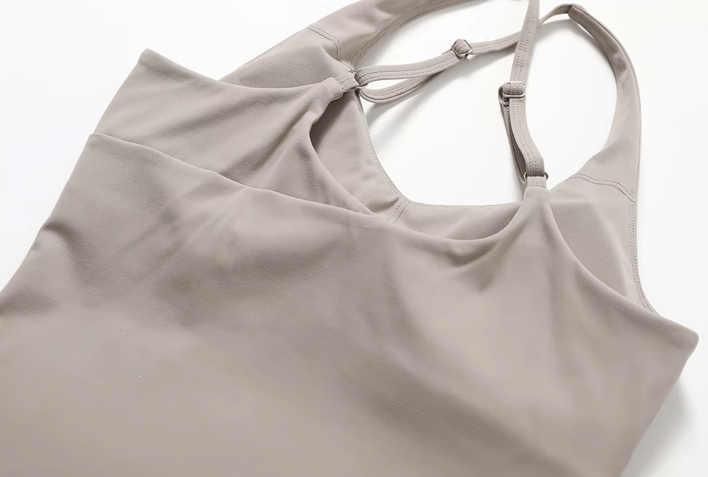 Women's cross-back adjustable yoga tank in beige, made of breathable nylon-spandex for fitness training and gym workouts.
