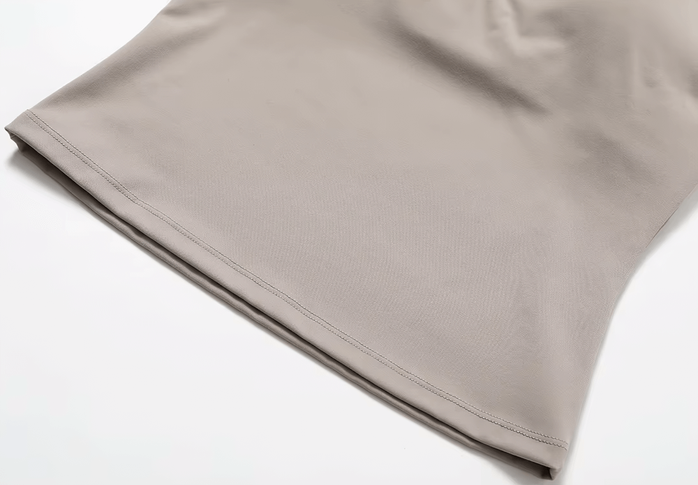 Sleek beige hem of Women's Cross-Back Adjustable Yoga Tank Top, highlighting breathable nylon and spandex fabric for active lifestyle.