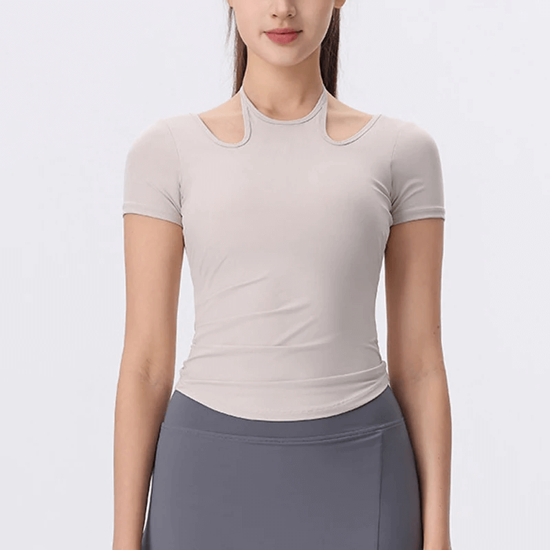 Woman wearing a cross-back athletic yoga T-shirt, featuring unique neckline and elastic fit, ideal for yoga and workouts.