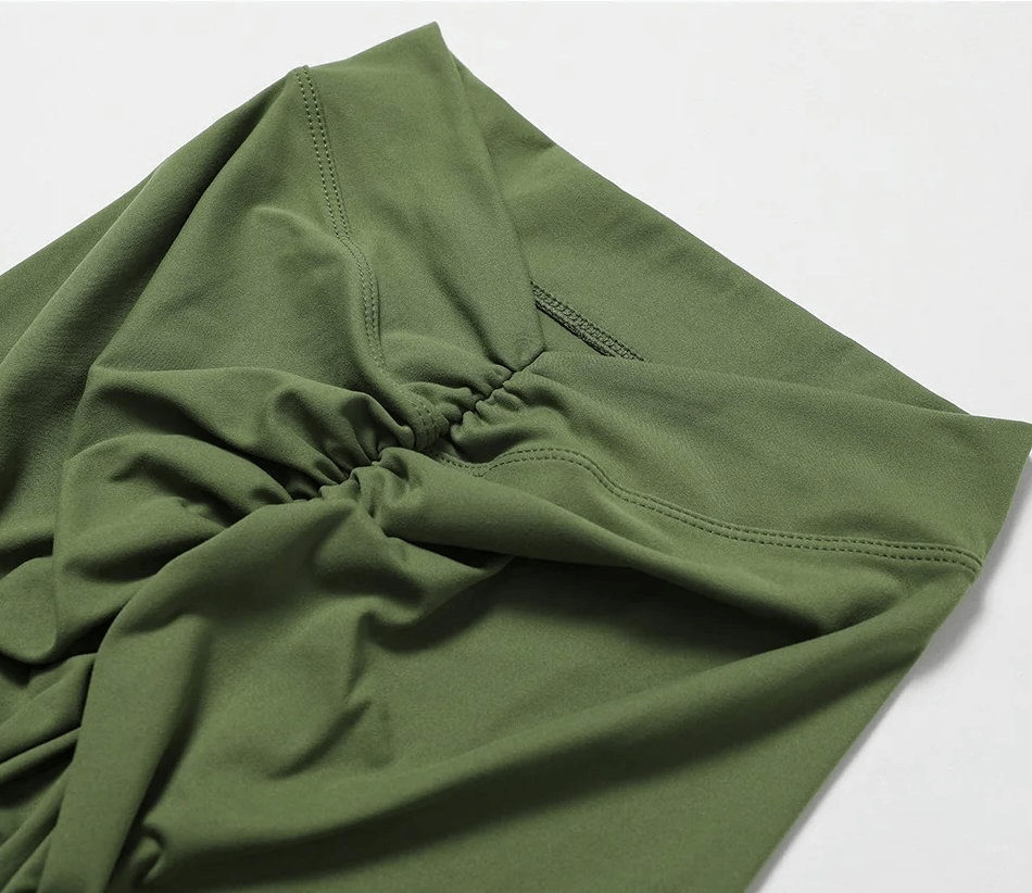 Green women's yoga shorts featuring elastic waistband and stylish ruched design, perfect activewear for flexibility and movement.