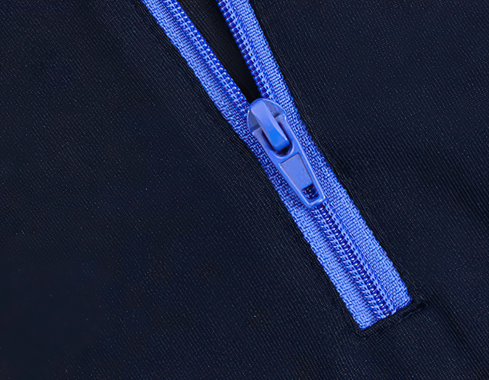 Close-up of blue zipper on women's thermal base layer, showcasing durable and stylish design for winter activities.