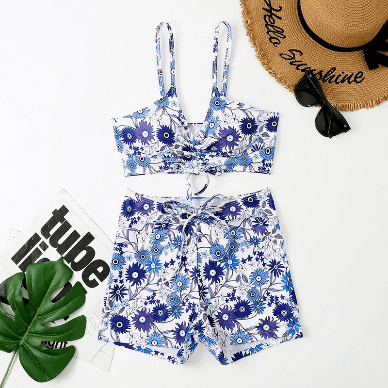 Women's flower print two-piece bathing suit SF1866, featuring blue floral pattern, laid flat with summer accents.