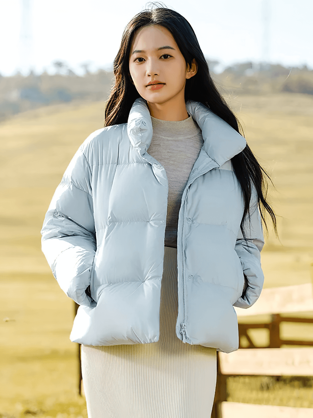 Woman wearing Women's Goose Down Jacket with Stand-Up Collar, SF2312, in a field, showcasing casual style and premium white goose down warmth.