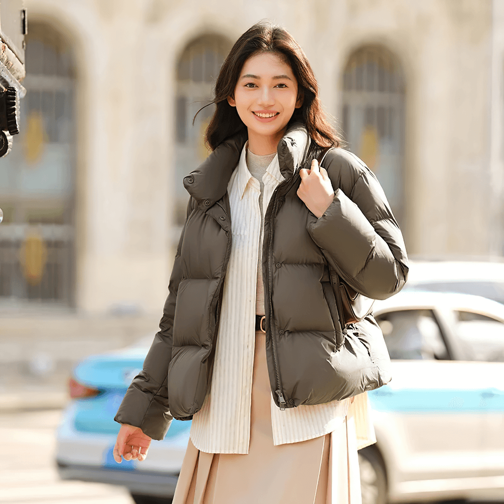 Woman wearing a women's goose down jacket with stand-up collar, SF2312 model, showcasing warmth and casual style, outdoor setting.