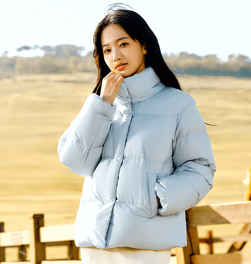 Woman wearing a sleek white goose down jacket with stand-up collar, casual and warm winter coat for everyday style.